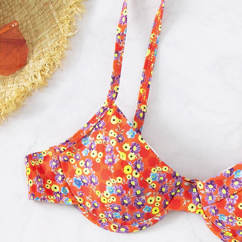 Floral bikini top on a white background with a straw hat.