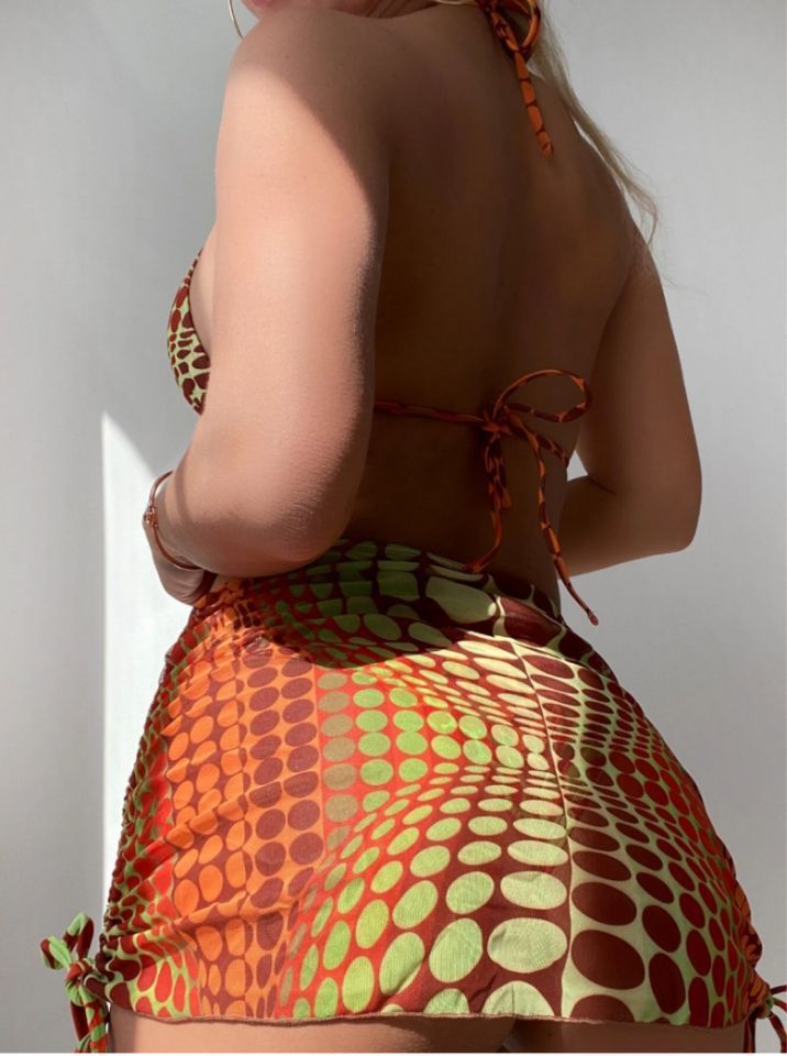 Person wearing a colorful patterned swimsuit against a plain background