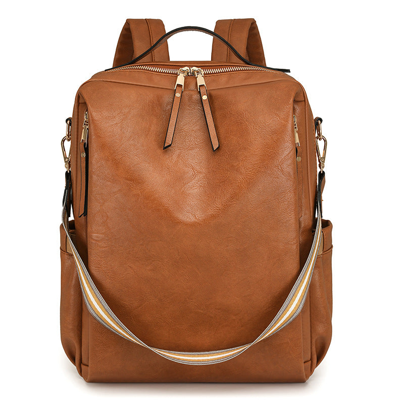 Brown leather backpack with gold zippers on a white background