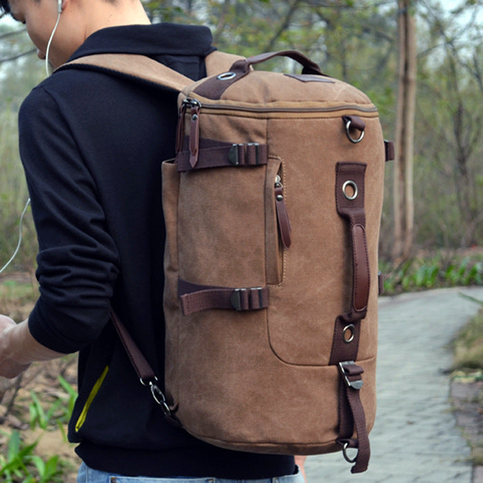 Person wearing a large brown backpack with leather straps in a natural setting.