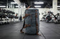 Gray backpack with brown straps in a gym