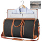 Black duffel bag with brown leather straps and trim, open to reveal clothes and a clear pouch.