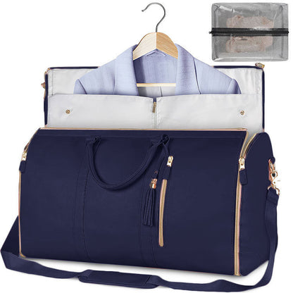 Navy blue travel bag with gold accents, open to reveal a shirt and accessories, on a white background.