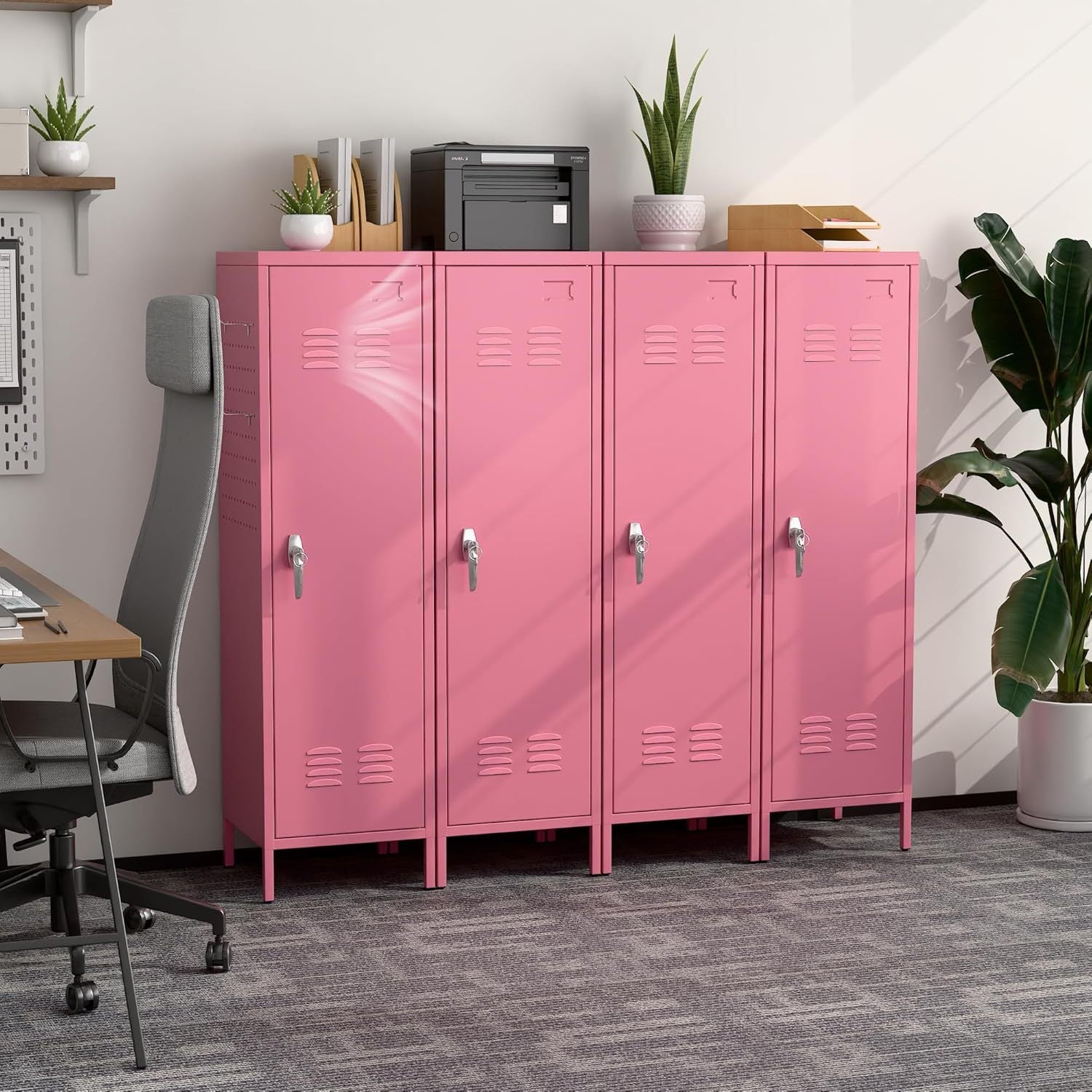 Pink lockers in an office setting with a desk and plants.
